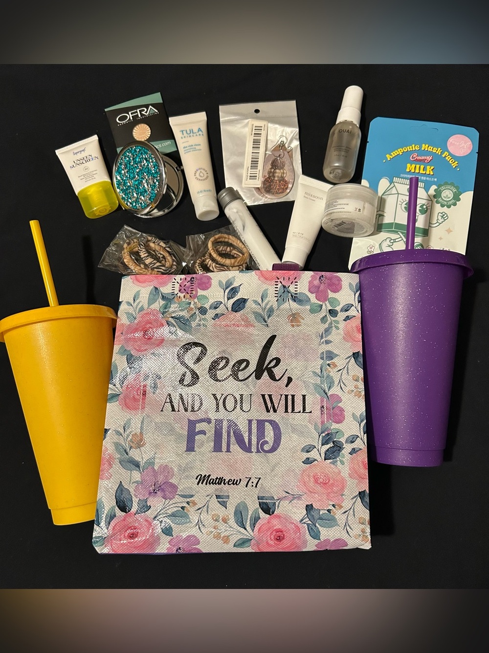 Reusable gift bag with 2 plastic glittery cups filled with products.